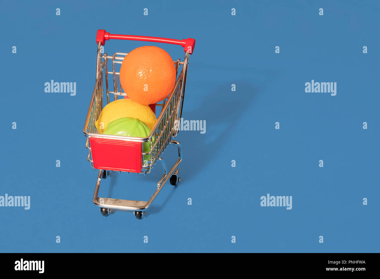 Toy Carrello trolley riempito con plastica la frutta e le verdure su uno sfondo blu con spazio per la copia e il testo Foto Stock
