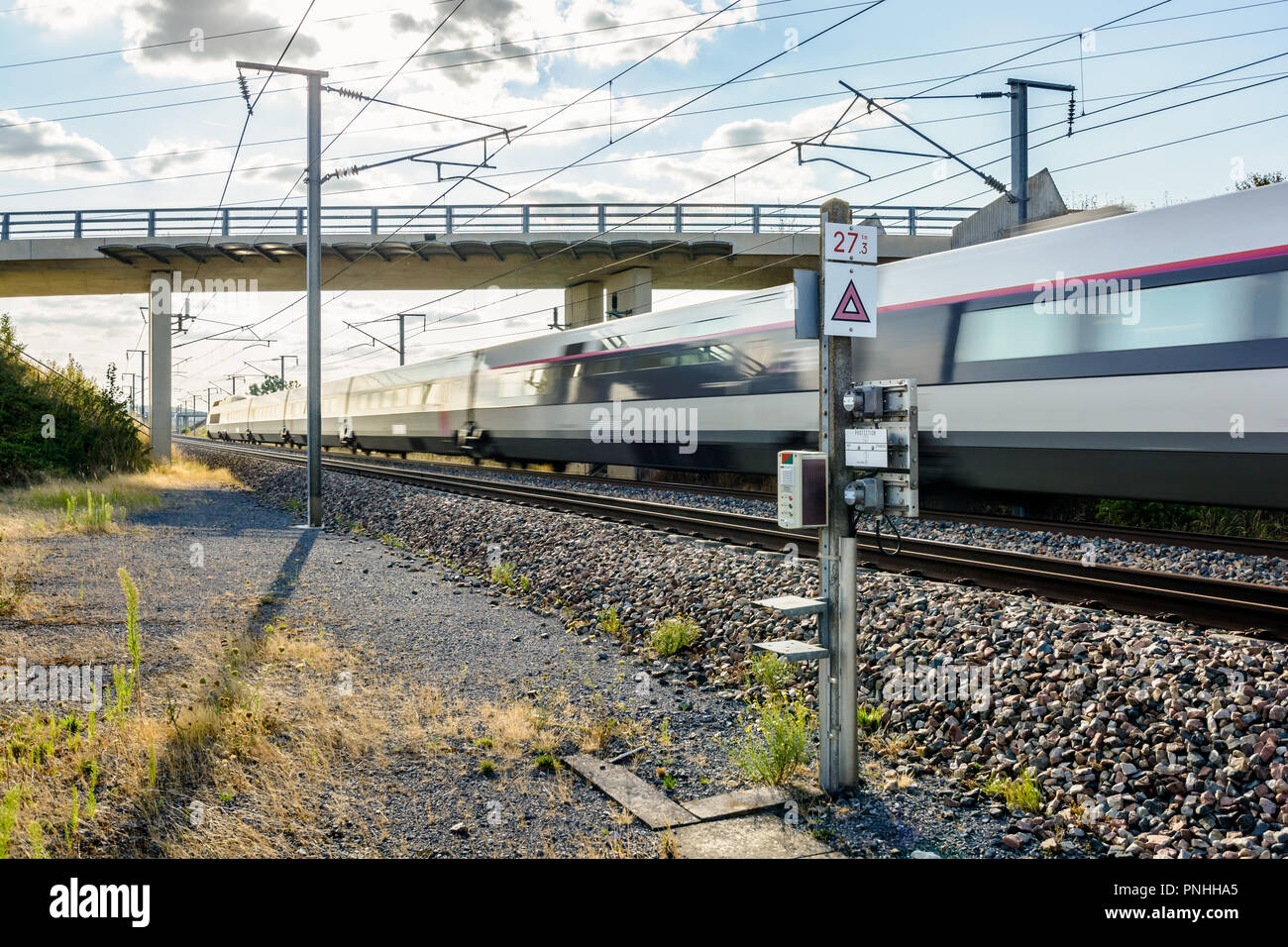 Vista dal lato del binario di un TGV il treno ad alta velocità dalla società francese SNCF passando sotto un ponte dell' Europa orientale la linea ferroviaria ad alta velocità Foto Stock