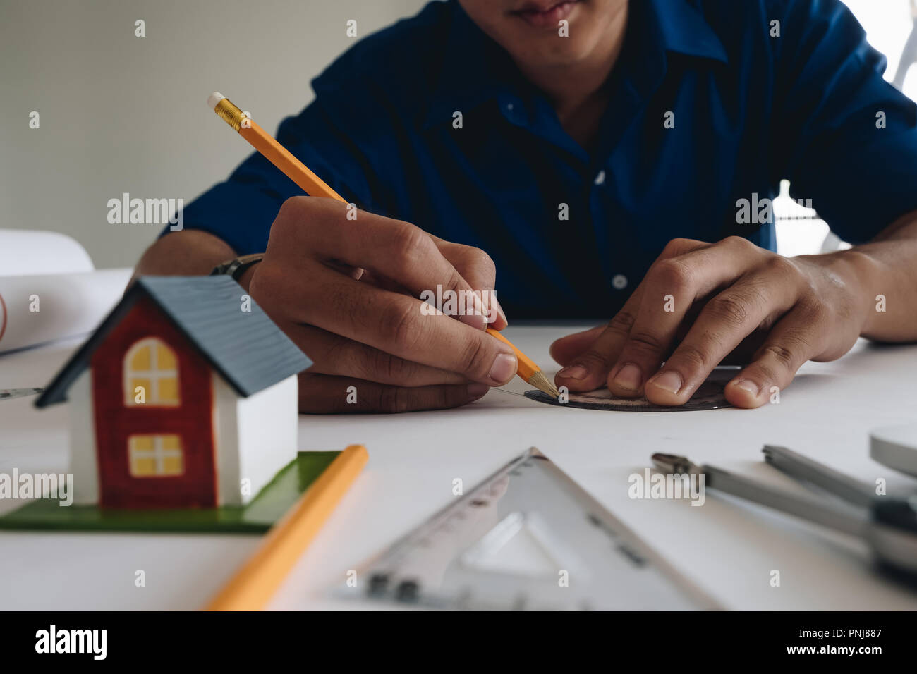 Giovane uomo che lavora per il suo progetto di piano presso il sito i lavori di costruzione. Foto Stock