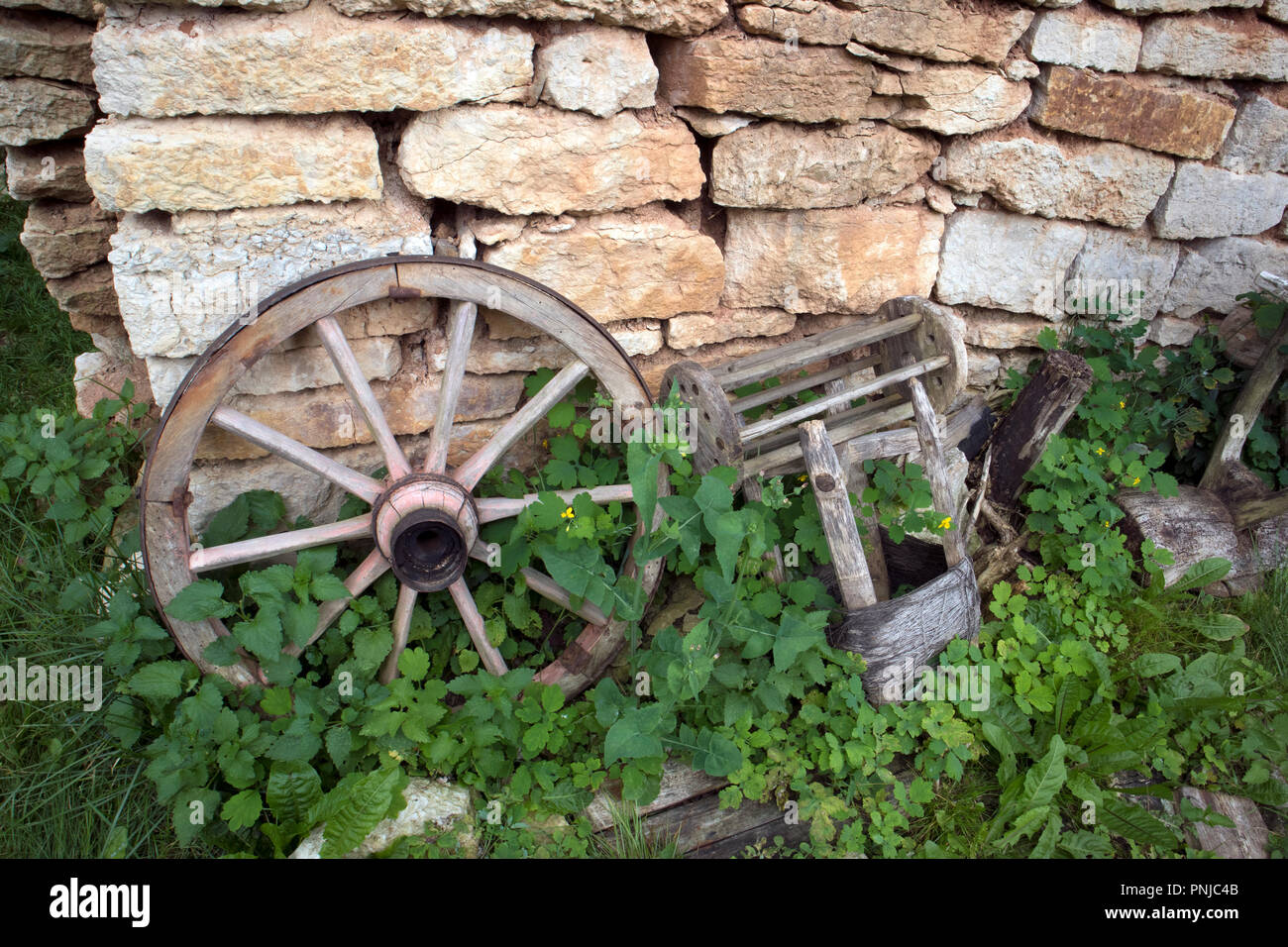 Open Air Museum di antiquariato cose contadina, ruota vecchia vicino al muro di mattoni Foto Stock