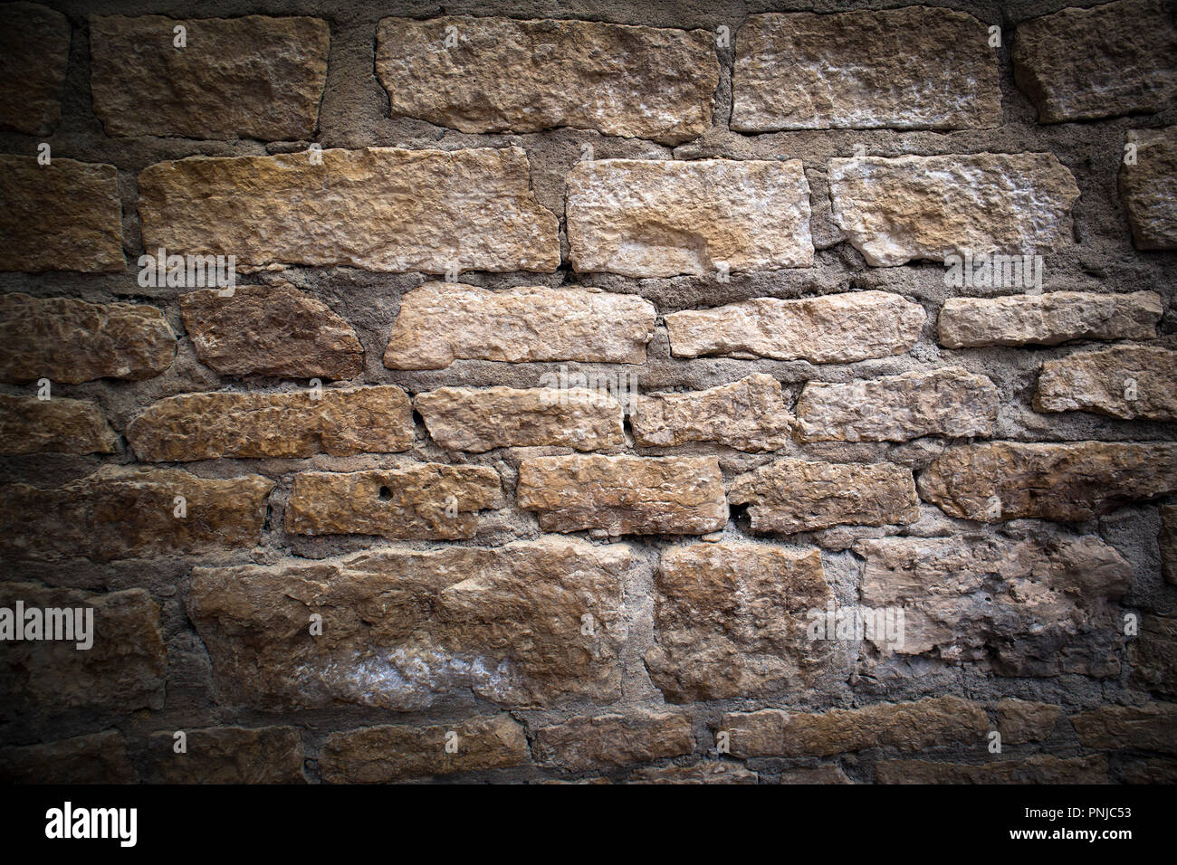 La muratura di antiquariato, frammento di antica sbriciolamento Mattoni di calcare muro di fortificazione, sfondo con oscurato vignette Foto Stock