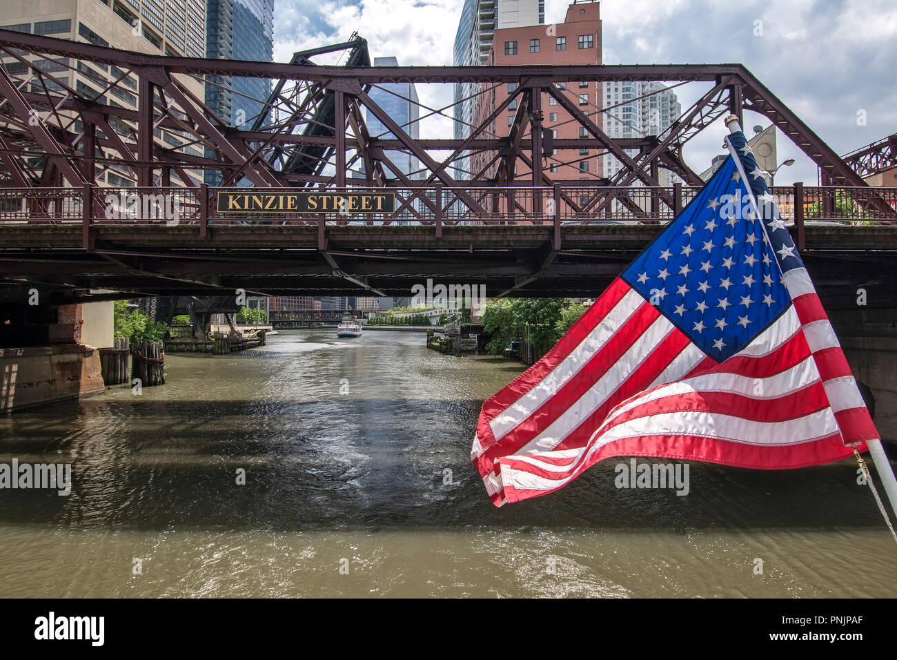 Bandiera americana su una barca sul fiume di Chicago con la Kinzie Street Bridge, Downtown Chicago, IL. Foto Stock