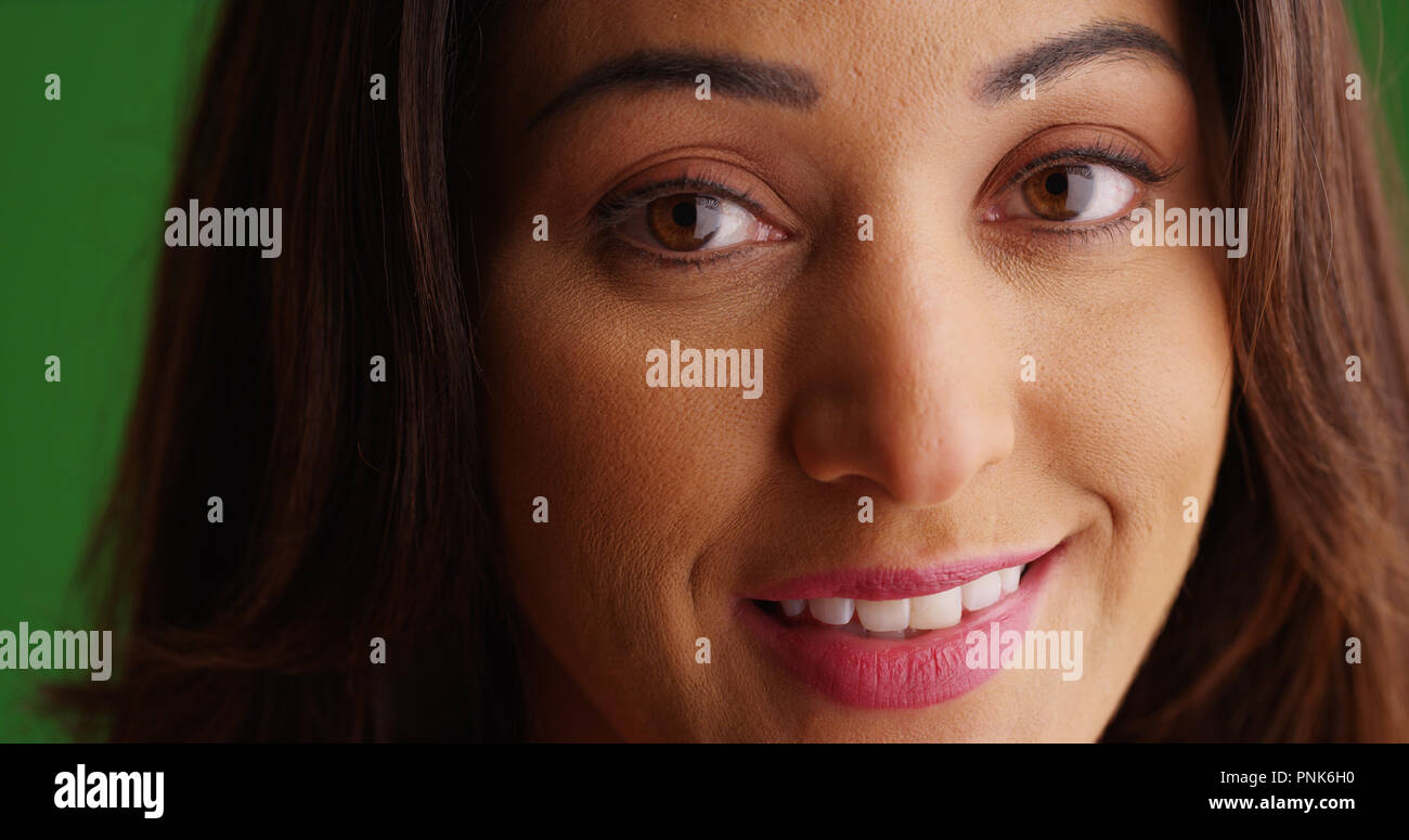 Close up di bella femmina Latina sorridente in Telecamera su schermo verde Foto Stock