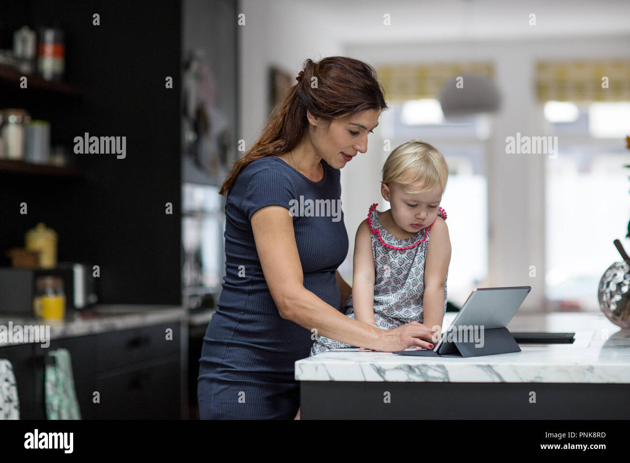 Donna incinta che lavora da casa Foto Stock