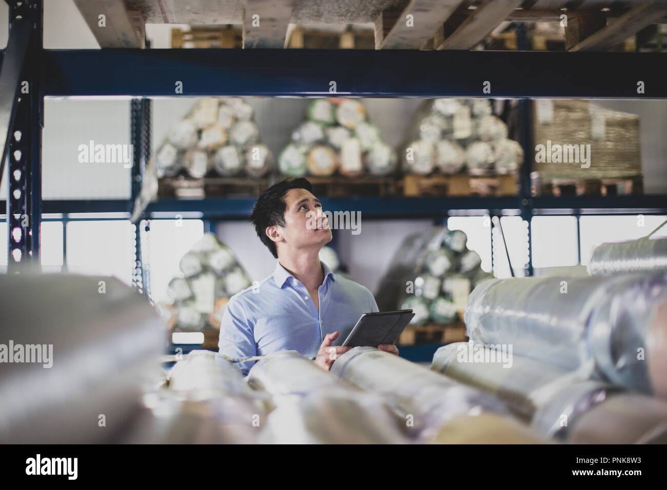 Lavoro maschio nel magazzino di distribuzione con tavoletta digitale Foto Stock