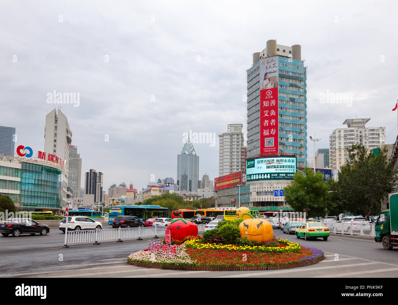 URUMQI, Xinjiang, Cina - 30 AGO 2017: strada trafficata intersezione con decorazioni di fiori Foto Stock