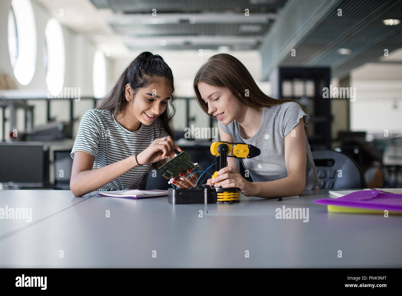 Alta scuola gli studenti che lavorano su un braccio robotico in classe Foto Stock