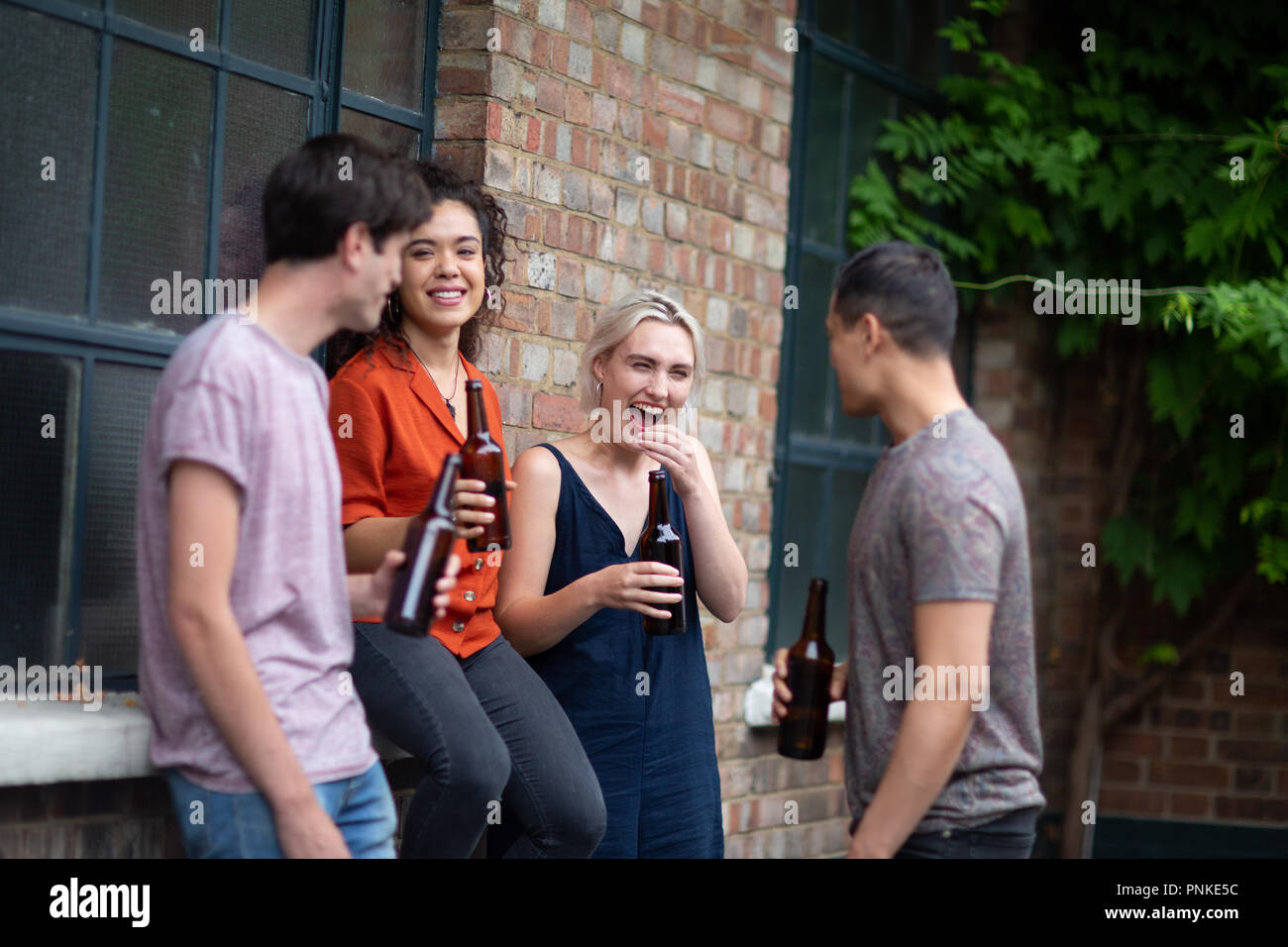 Millennial bere birra nei pub garden Foto Stock