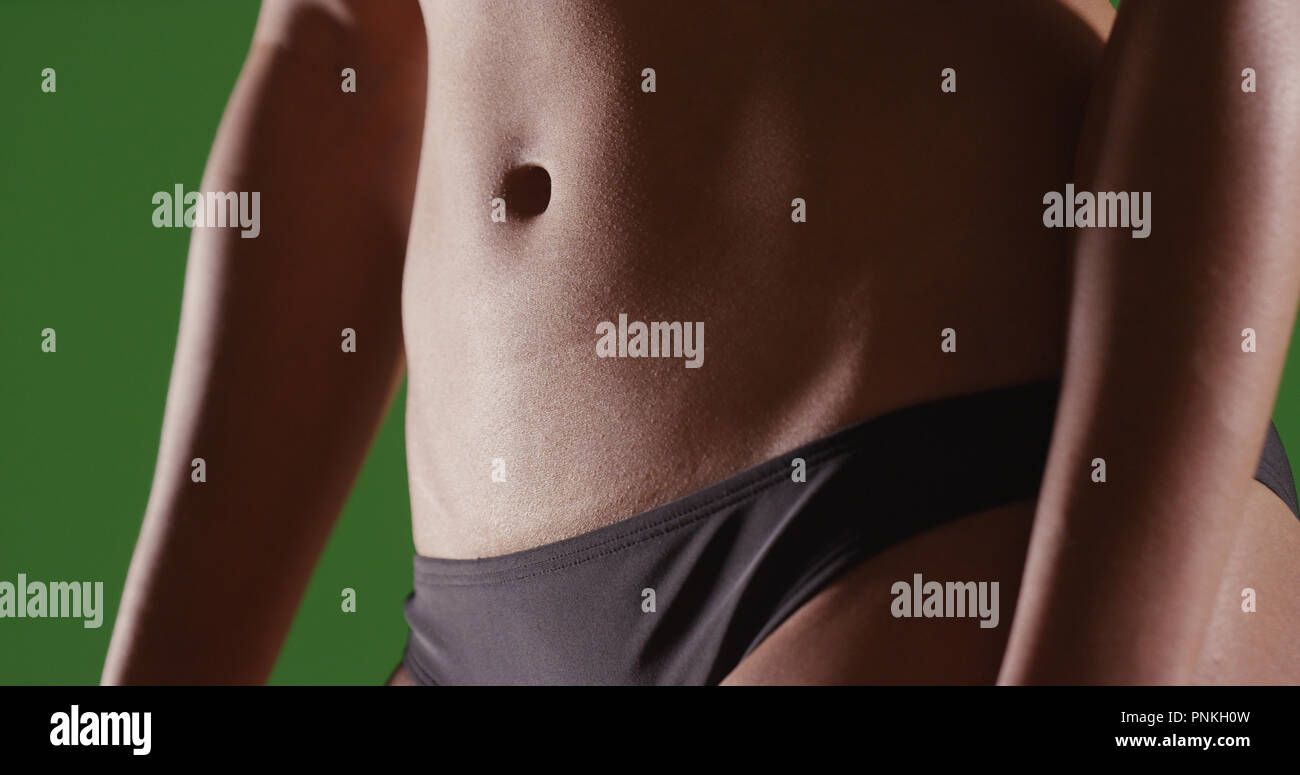 Primo piano della donna nei toni del piatto stomaco su schermo verde Foto Stock
