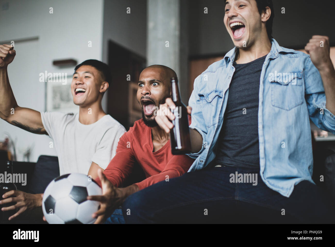 Amici maschi a guardare una partita di calcio Foto Stock