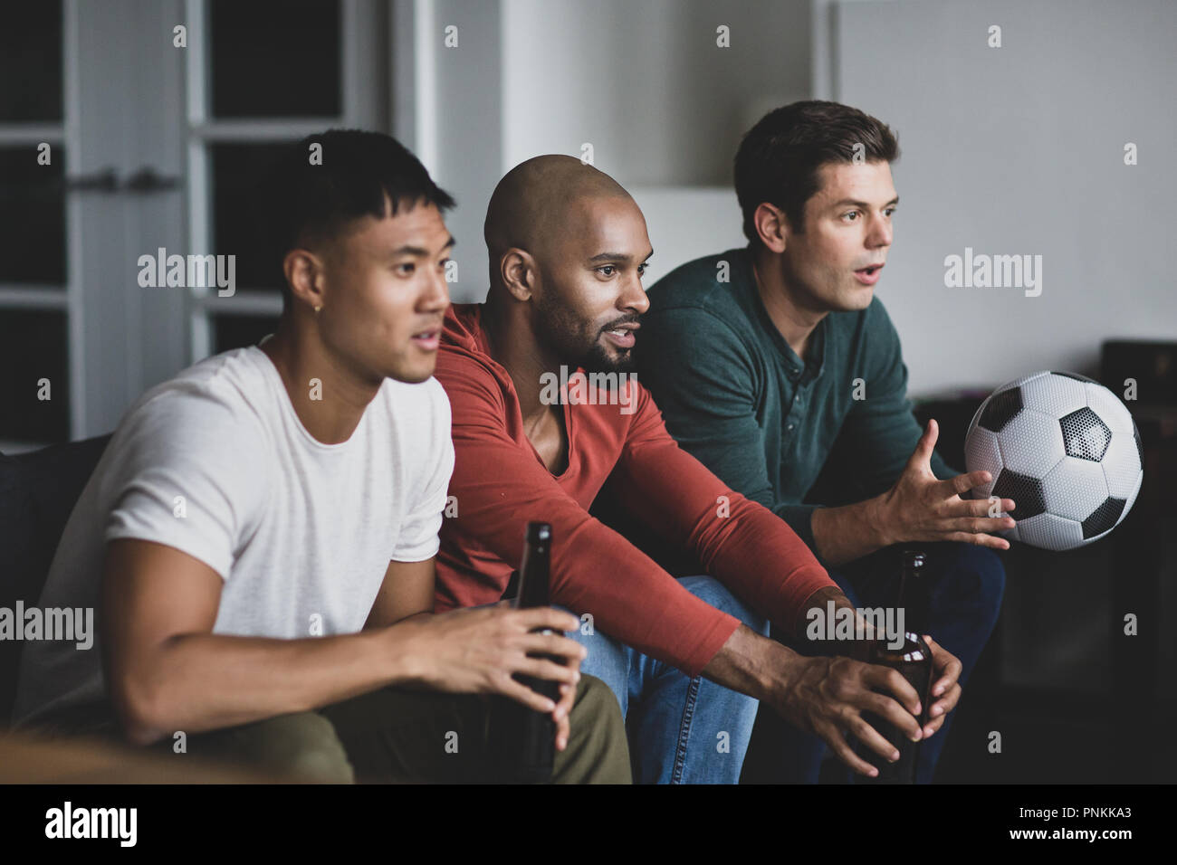 Amici maschi a guardare una partita di calcio Foto Stock