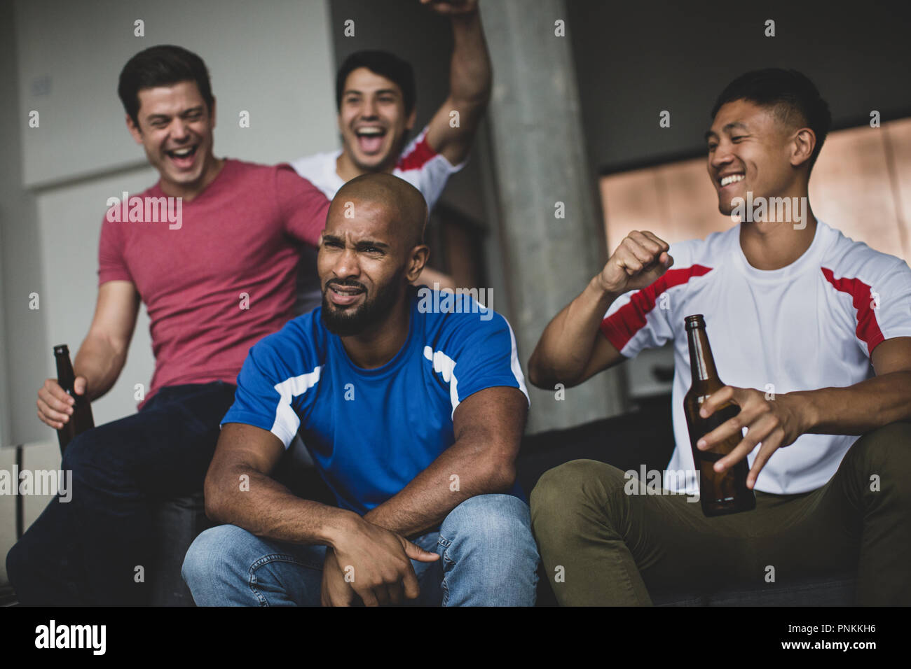 Gruppo di amici maschi a guardare una partita di calcio Foto Stock