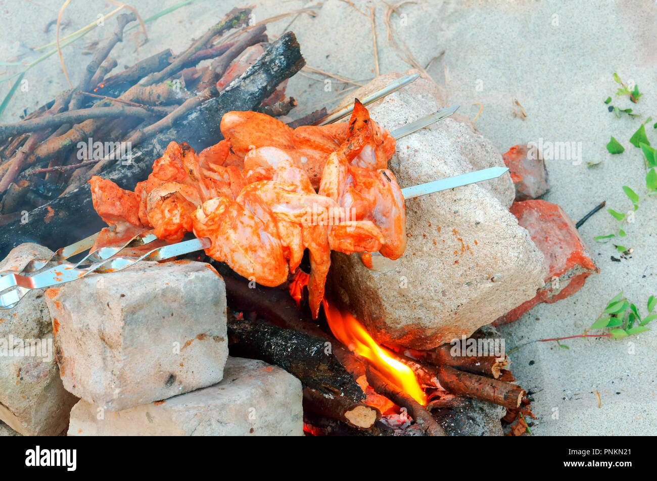 Il pollo è cotta sul fuoco, ali di pollo rfi su spiedini sul fuoco Foto Stock