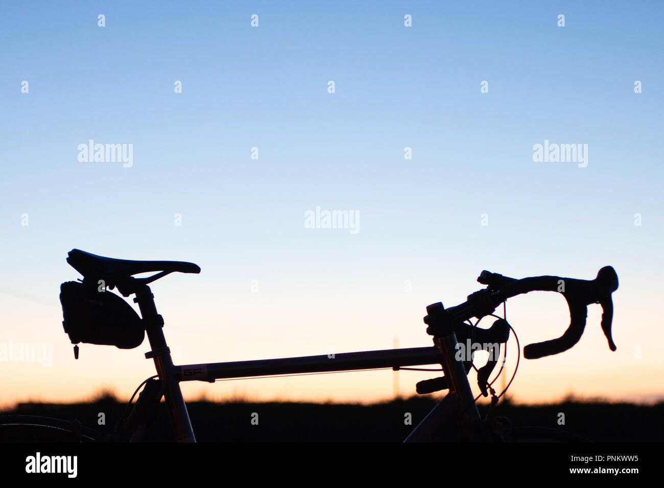 La metà superiore di una bici con sfondo al tramonto Foto Stock