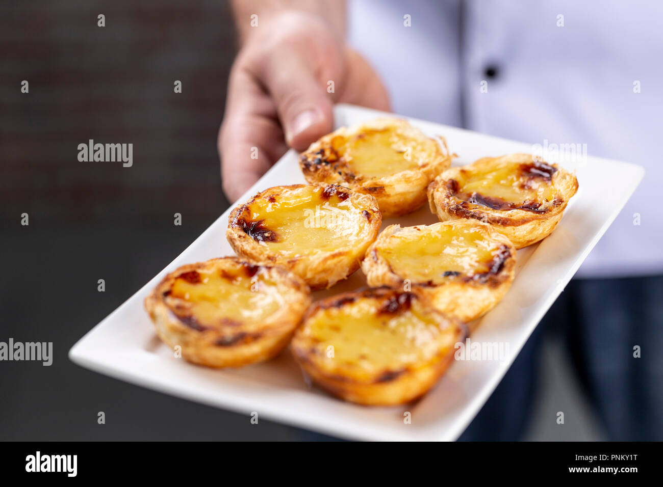 Tipico portoghese torte di crema - 'Pastel de Nata' o 'Pastel de Belem'. tradizionale pasticceria portoghese. azienda da uno chef. Foto Stock