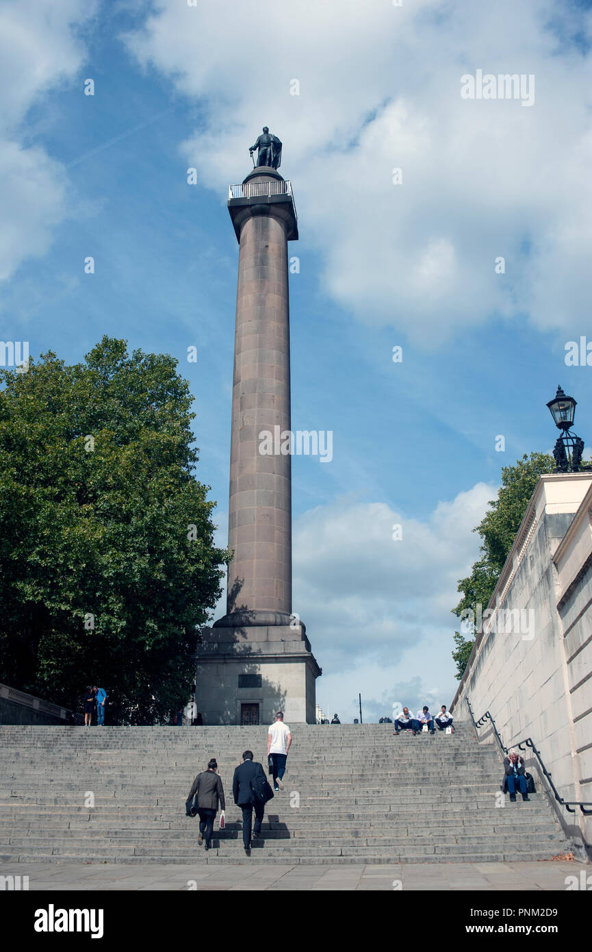 Il duca di York colonna alla sommità del Duca di York passi, London, Regno Unito con diverse persone a piedi fino e seduti sulle fasi. Foto Stock