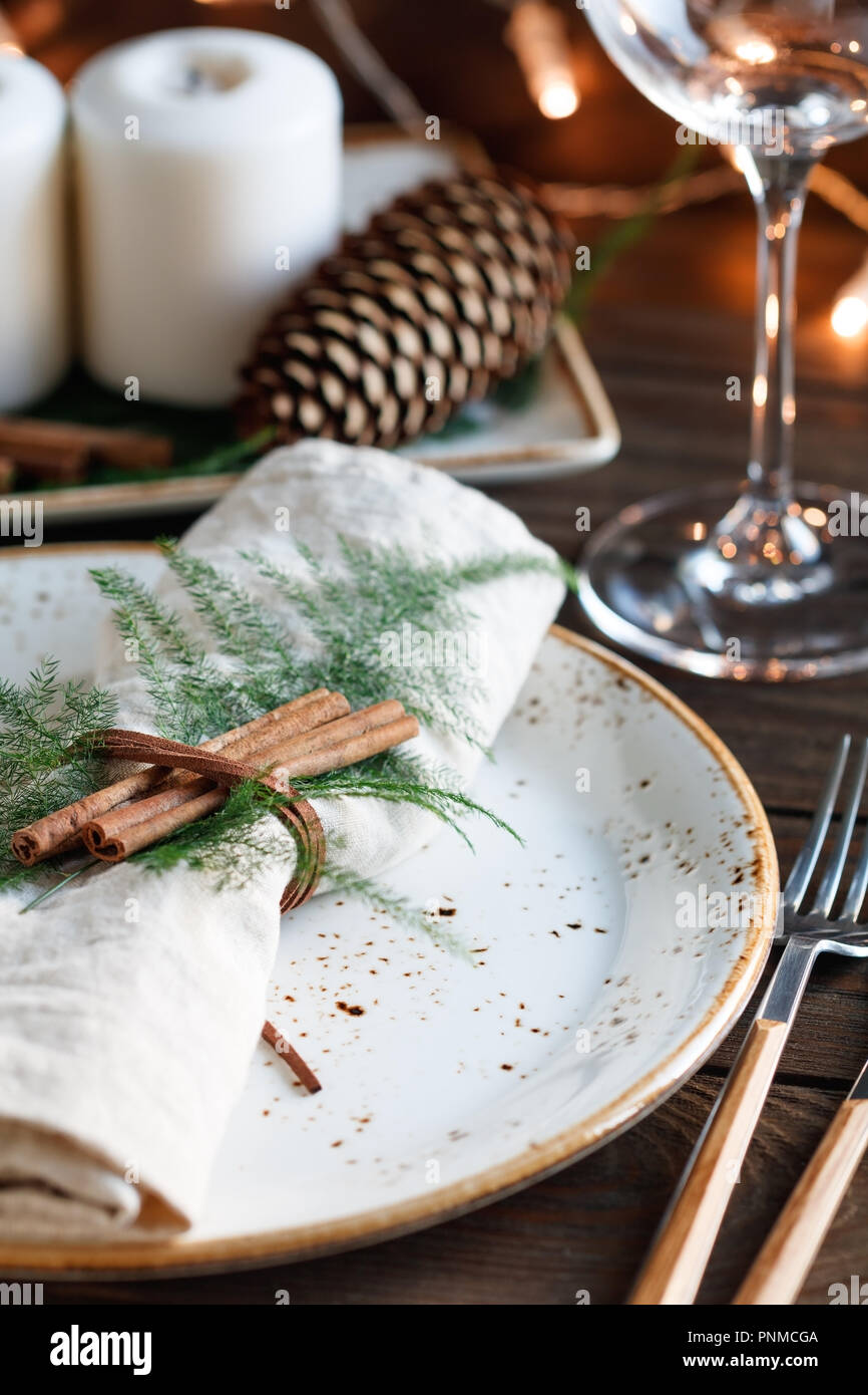 Ringraziamento impostazione tabella tra candele bianche e i coni. Decorate biancheria igienico da bastoncini di cannella. Il concetto di una cena di gala. Foto Stock