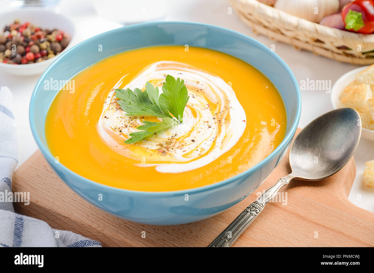 Zuppa di zucca con panna e prezzemolo sul tavolo bianco. Foto Stock