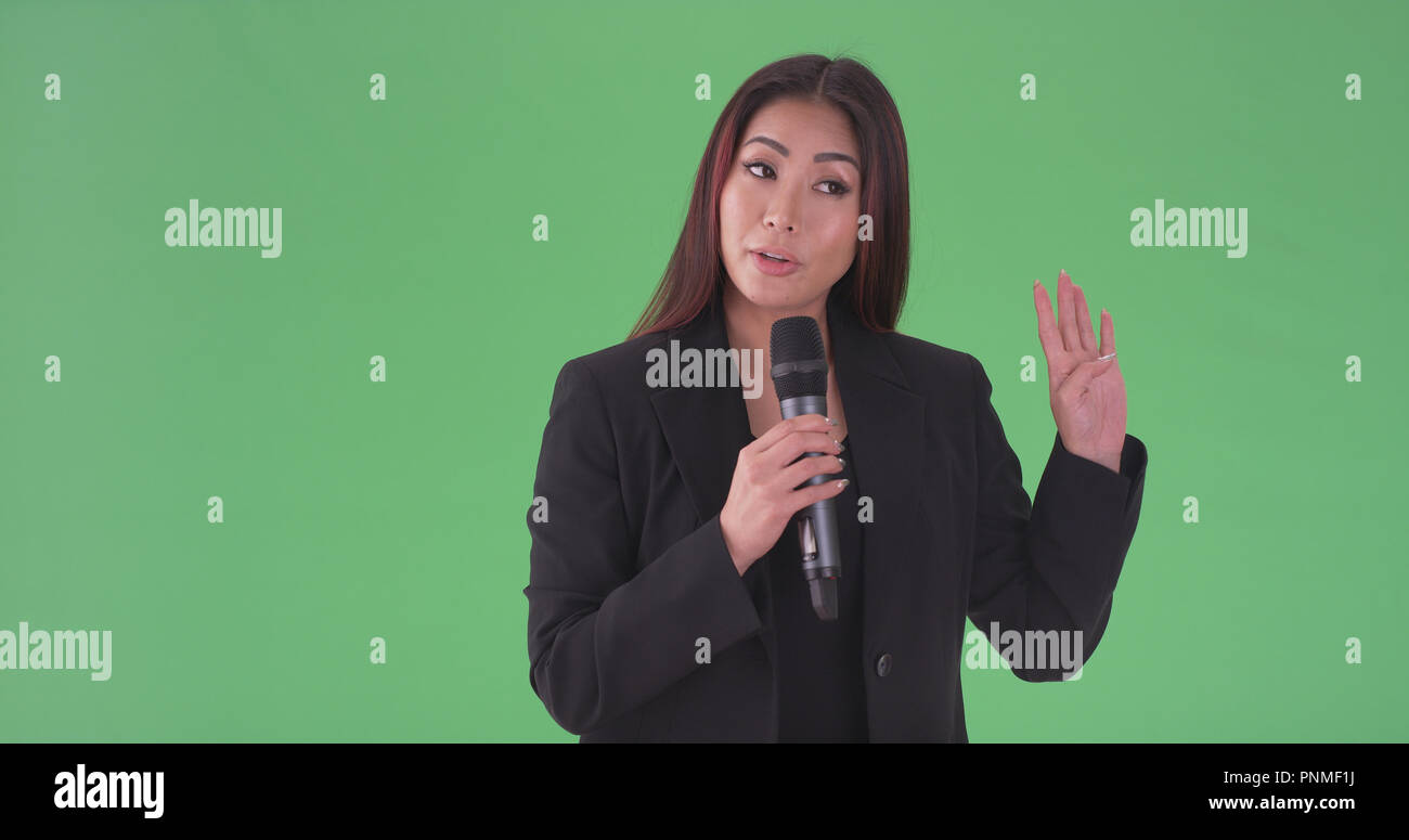Asian millenaria imprenditrice parlare attraverso il microfono su schermo  verde Foto stock - Alamy