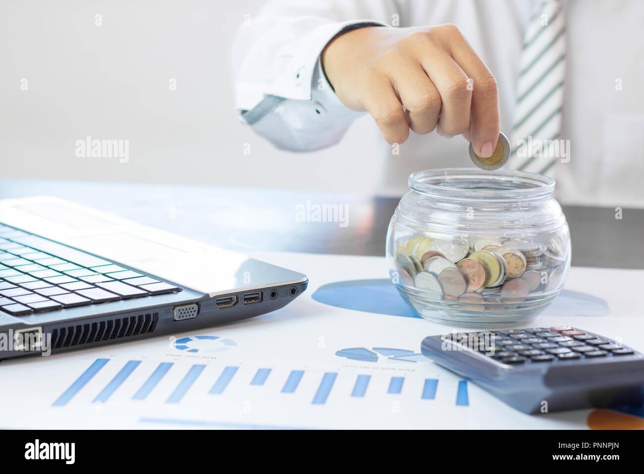 La mano di imprenditore impilati denaro monete in vaso, concetto come finanziare, di risparmio e di capitale bancario. Foto Stock