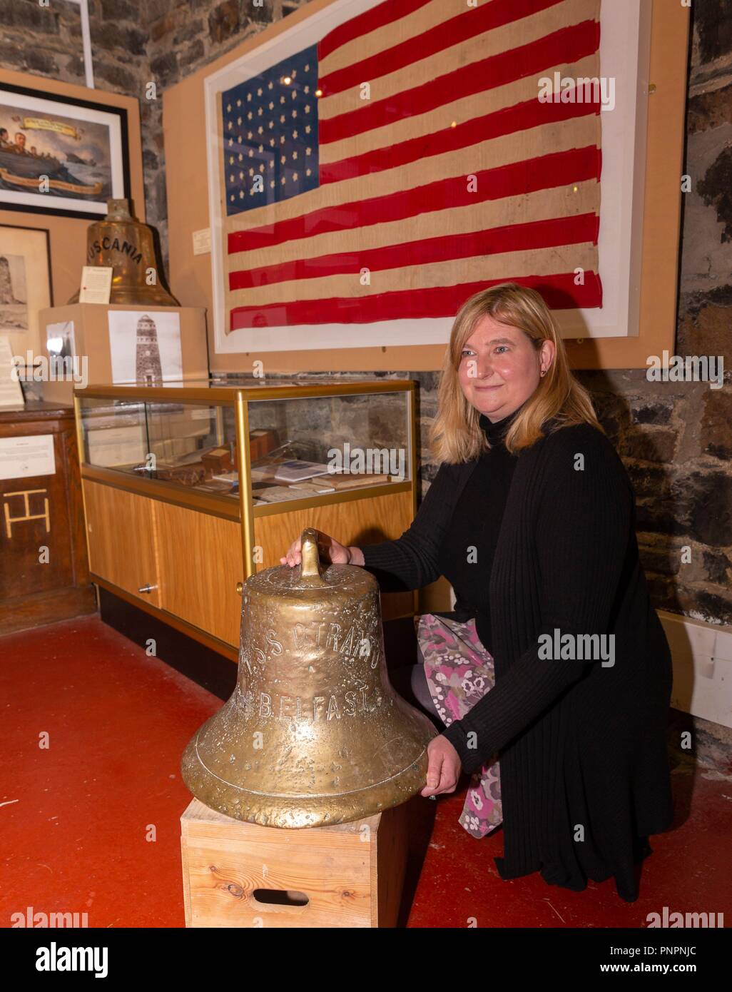 Islay, UK. Il 22 settembre 2018. La nave di campana appartenente alla SS Otranto che fu affondato nel Machir Bay al largo dell'isola scozzese di Islay è andato in mostra al Museo di Islay vita nel porto di Charlotte. Nella foto: Museo manager, Jenni Minto con la campana della SS Otranto. In fondo è un indicatore che è stato prestato al museo da Credito: ricca di Dyson/Alamy Live News Foto Stock