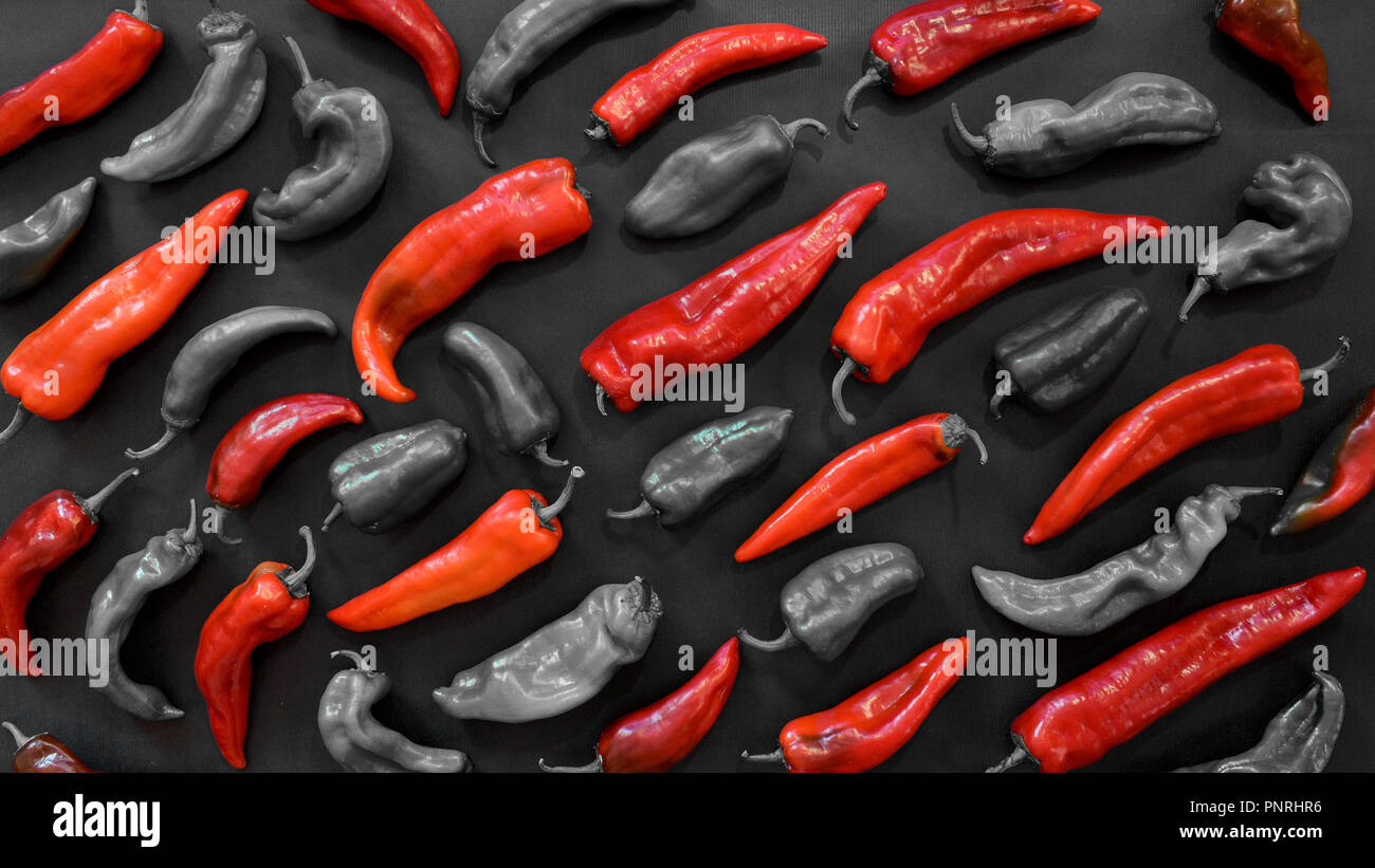 Amore Rosso per alimenti. Motivo fotografico di peperoni rossi su sfondo scuro. Verdure sfondo astratto. Vista dall'alto. Concetto di rosso. Foto Stock