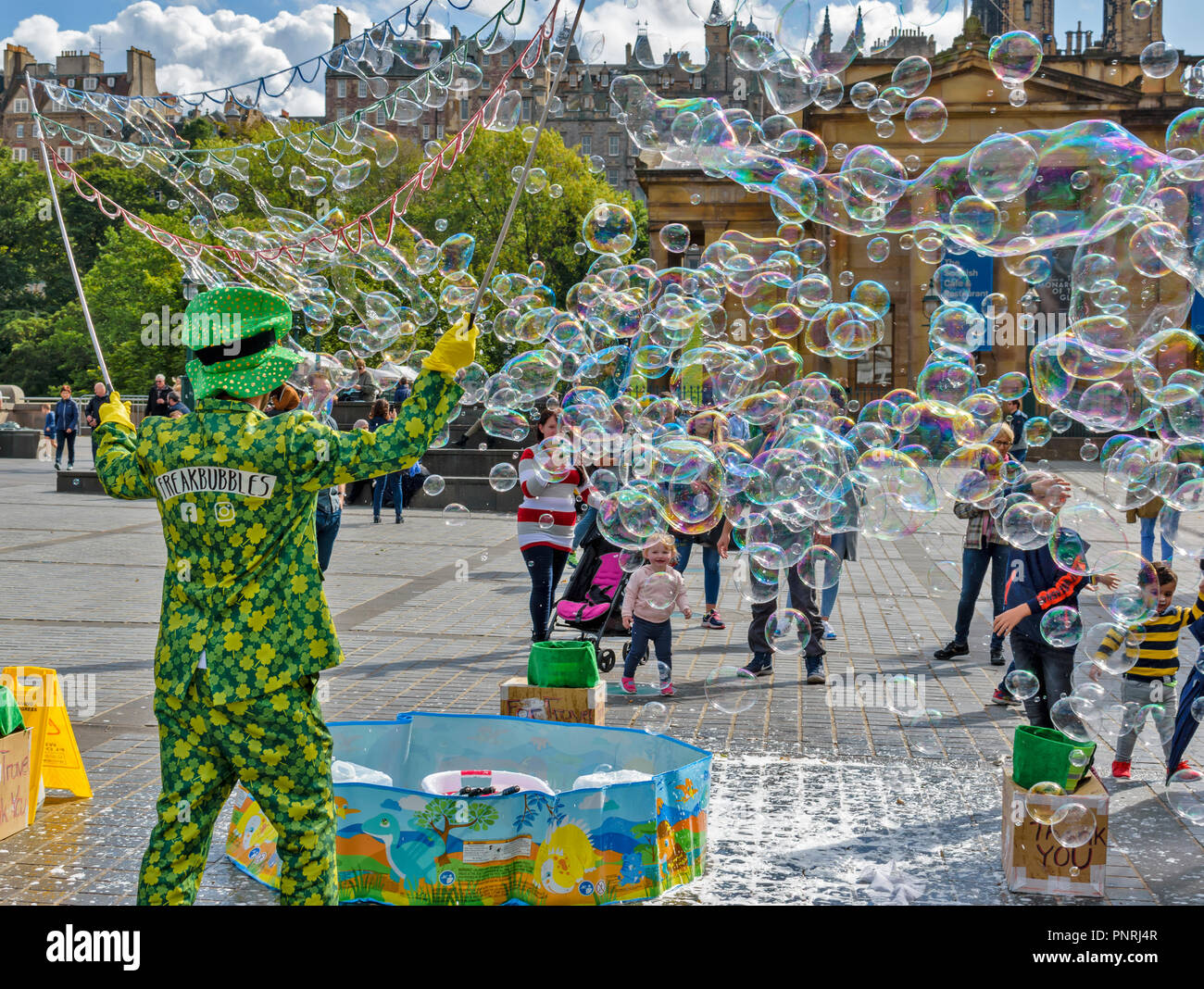Edimburgo Scozia centro città spettatori coperto con bolle di sapone soffiata nel vento Foto Stock