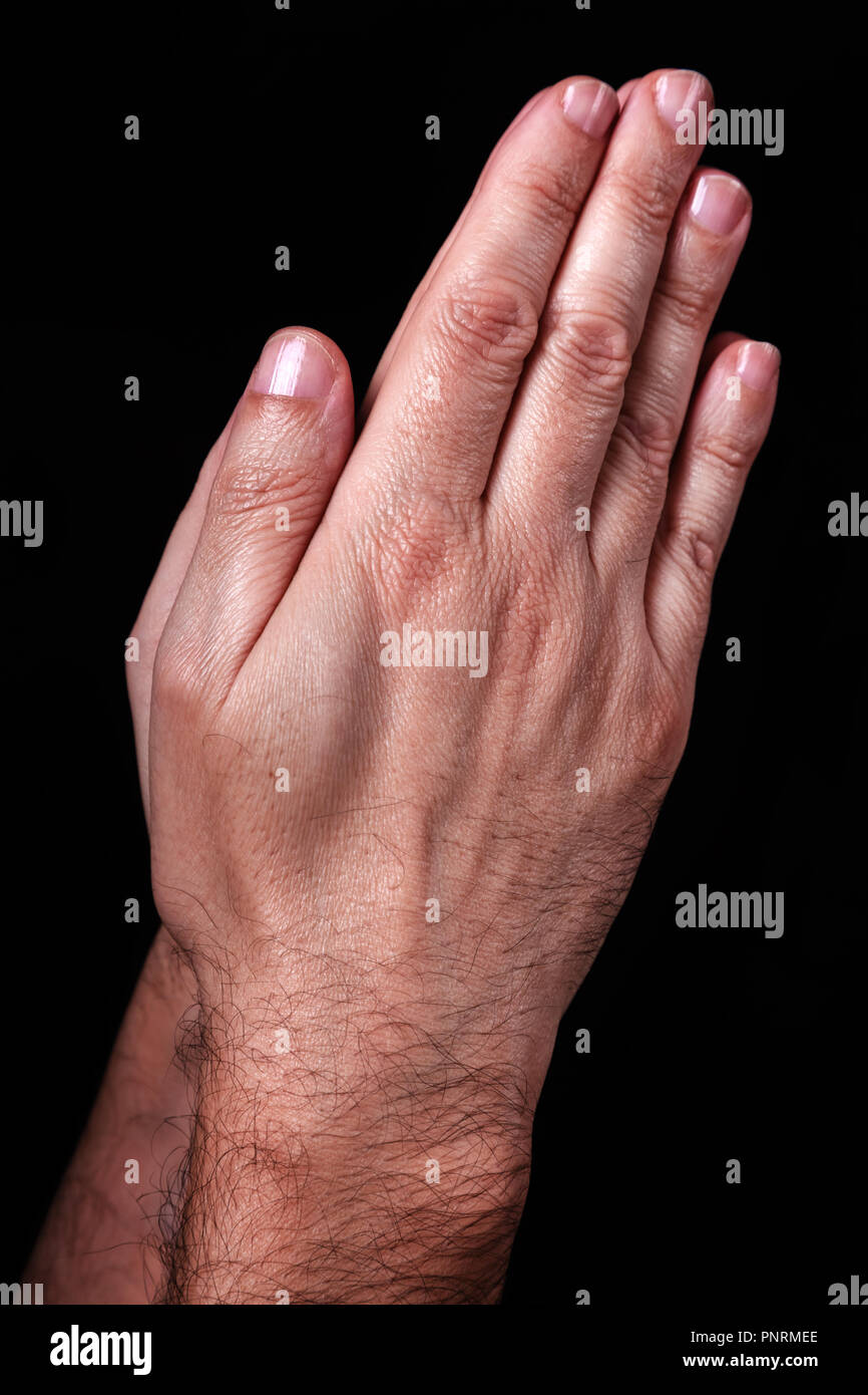 Mani maschio pregando con palme insieme. Sfondo nero. Close up man mano. Concetto di preghiera, di pregare, di fede e di religione, religiosi, di culto Foto Stock