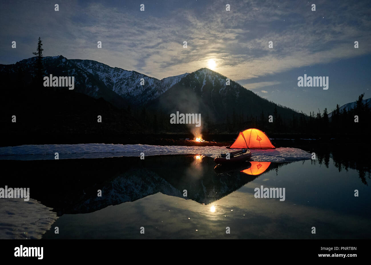 Tenda arancione sulla costa del lago di notte. Foto Stock