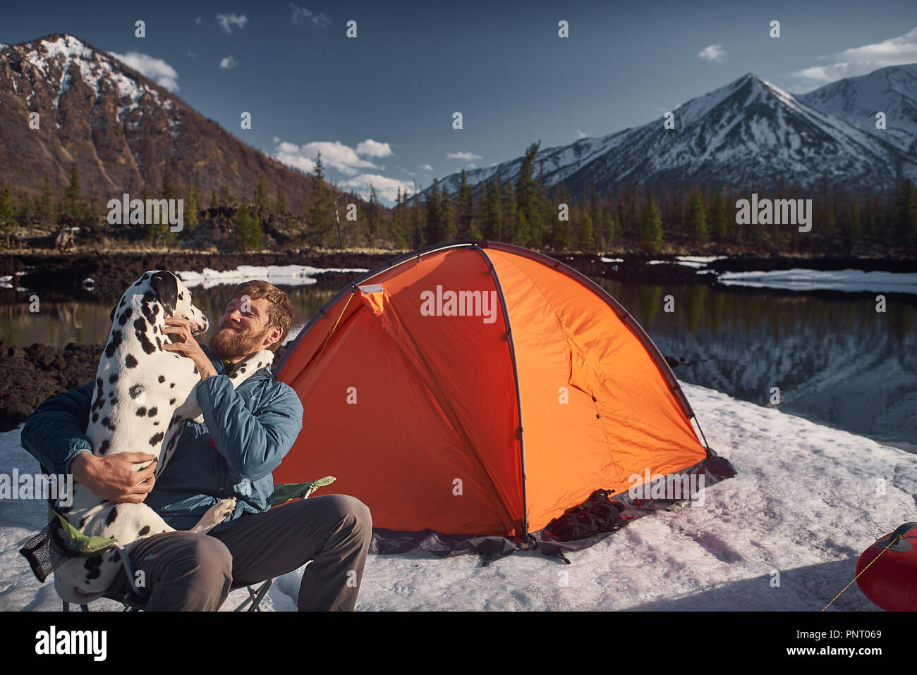 L'uomo gioca con il suo cane al campeggio all'aperto Foto Stock