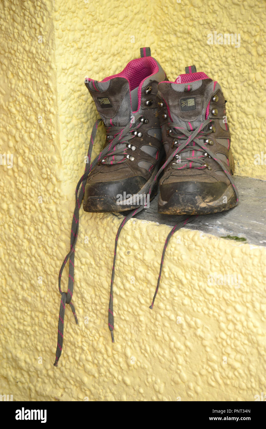 Terreni fangosi scarponcini da trekking fuori ad asciugare al sole Foto Stock