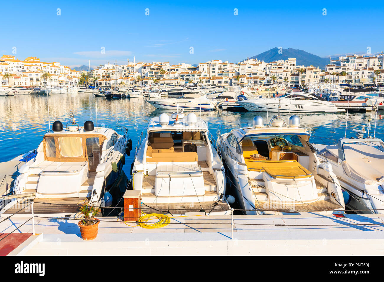 Vista del porto turistico di Puerto Banus con barche e case bianche in Marbella città di sunrise, Andalusia, Spagna Foto Stock
