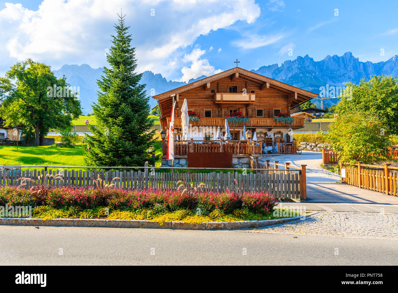Tirolo, Austria - Luglio 29, 2018: in legno tipico casa alpina contro lo sfondo delle montagne a Going am Wilden Kaiser villaggio sulla soleggiata giornata estiva. Questo pl Foto Stock