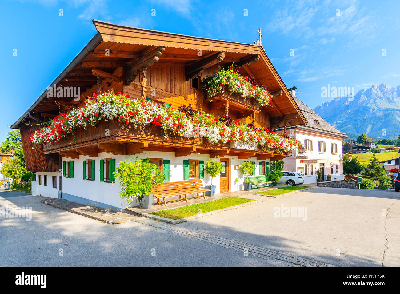 Tirolo, Austria - Luglio 29, 2018: in legno tipico casa alpina contro lo sfondo delle montagne a Going am Wilden Kaiser villaggio sulla soleggiata giornata estiva. Questo pl Foto Stock