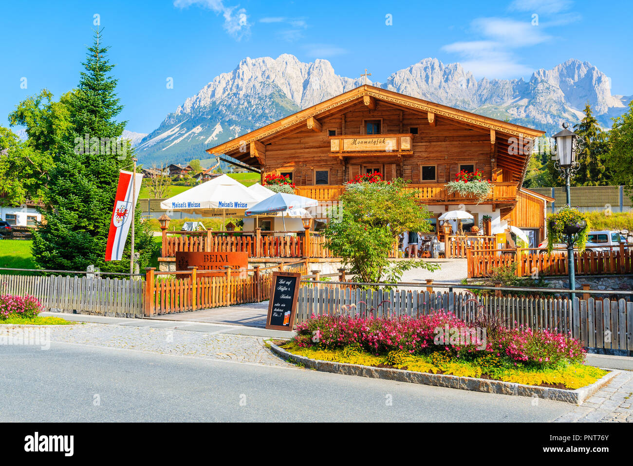 Tirolo, Austria - Luglio 29, 2018: tipico alpino in legno guesthouse contro lo sfondo delle montagne a Going am Wilden Kaiser villaggio sulla soleggiata giornata estiva. Th Foto Stock