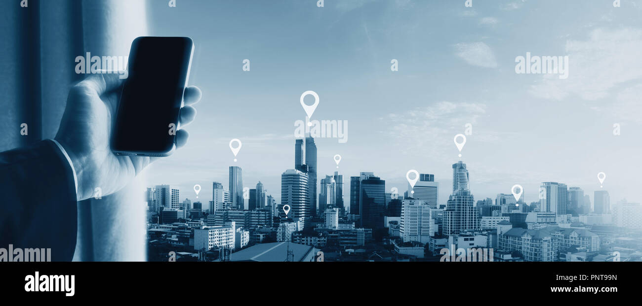 Mano azienda mobile smartphone e vista sulla città. Telefono cellulare il GPS del sistema di posizionamento globale della tecnologia di navigazione Foto Stock