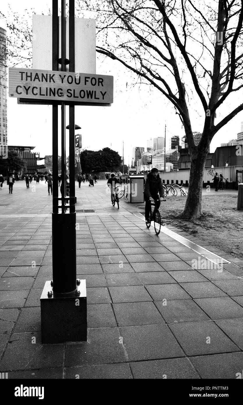 I ciclisti in sella passato un grazie per il ciclismo segno lentamente, Melbourne VIC, Australia Foto Stock