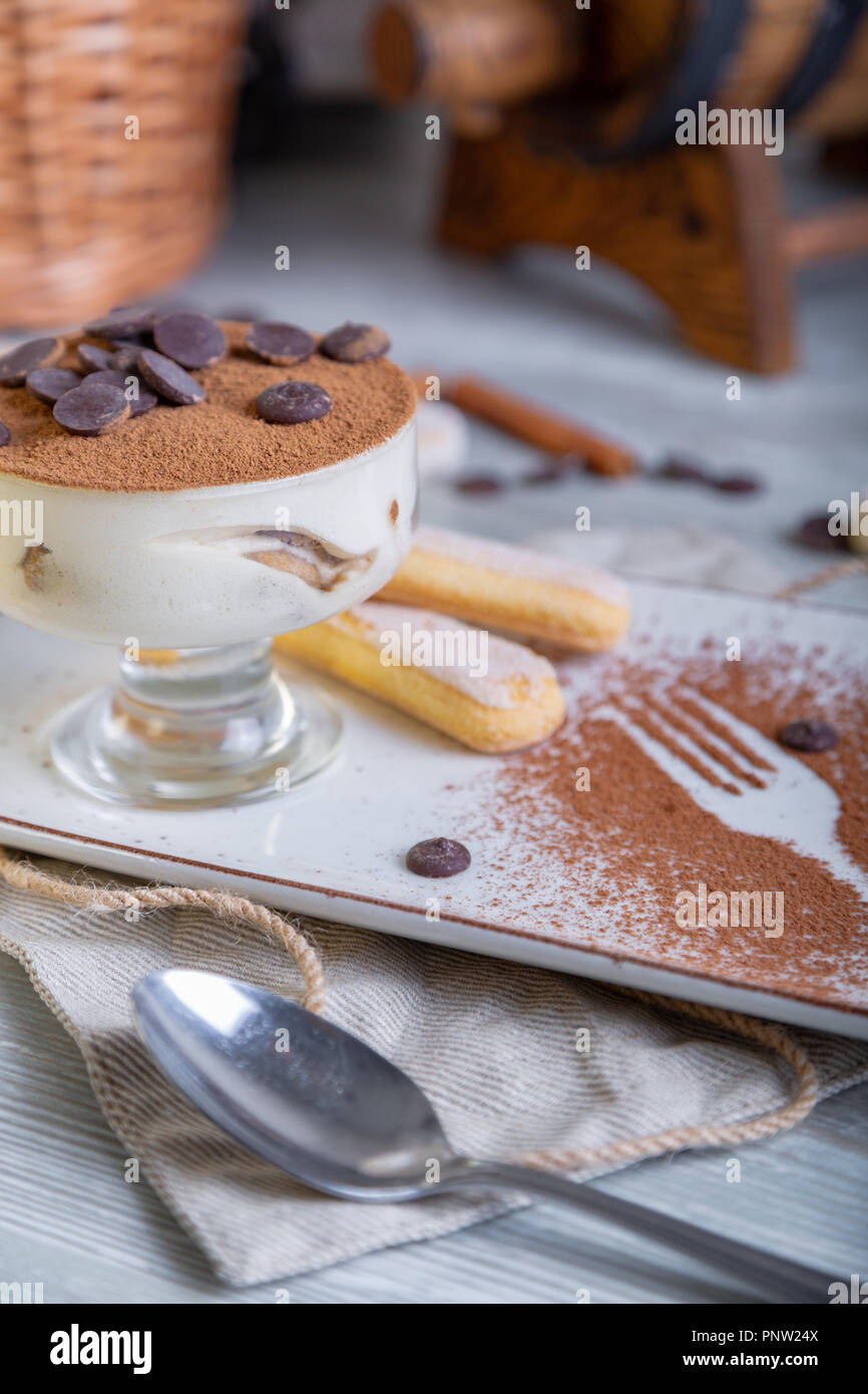 Vista ravvicinata della bellissima ed elegante dessert, tiramisù, servito sulla piastra. Bella decorazione, ristorante piatto pronto da mangiare. Tea time, atmosfera accogliente. Foto Stock