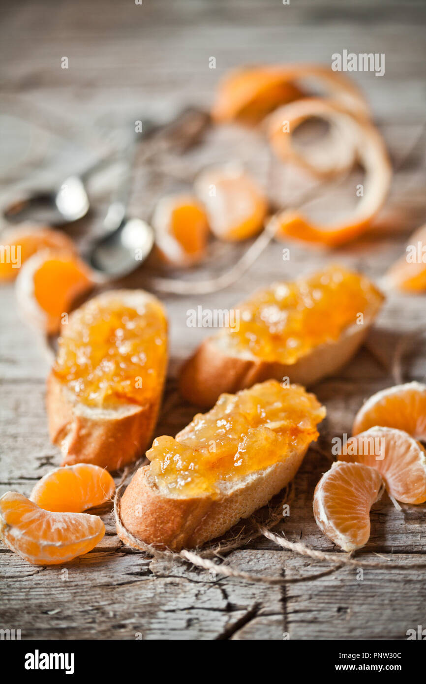 Pezzi di baguette con marmellata di arance closeup rustico di legno Foto Stock
