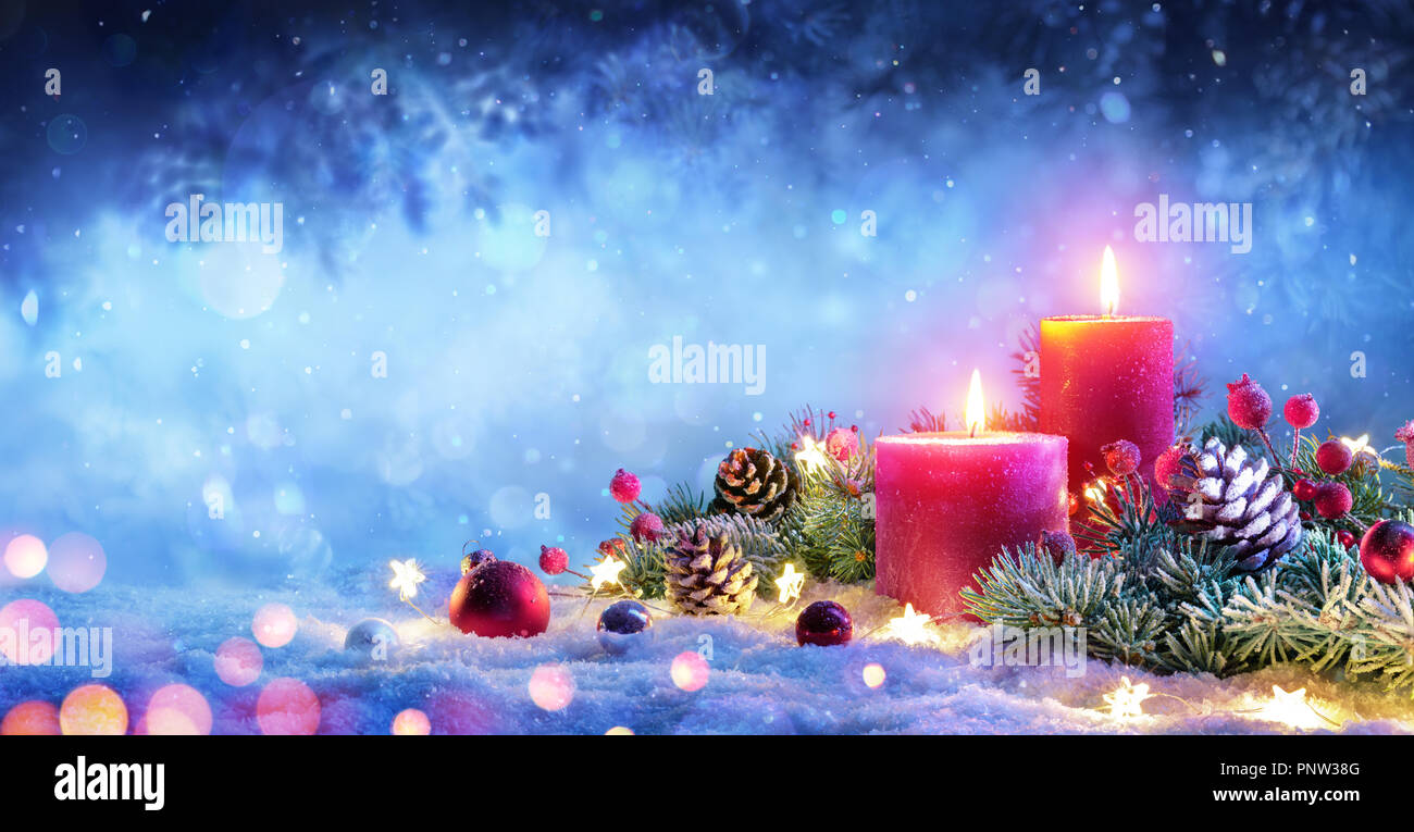 Avvento natale - candele rosse con ornamento sulla neve Foto Stock