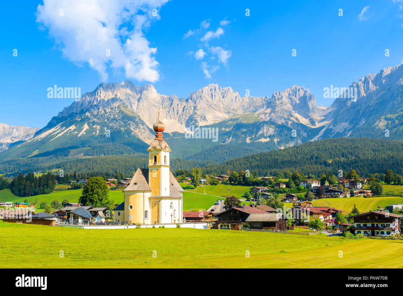 Chiesa sul prato verde a Going am Wilden Kaiser villaggio montano su soleggiate giornate estive, Tirolo, Austria Foto Stock