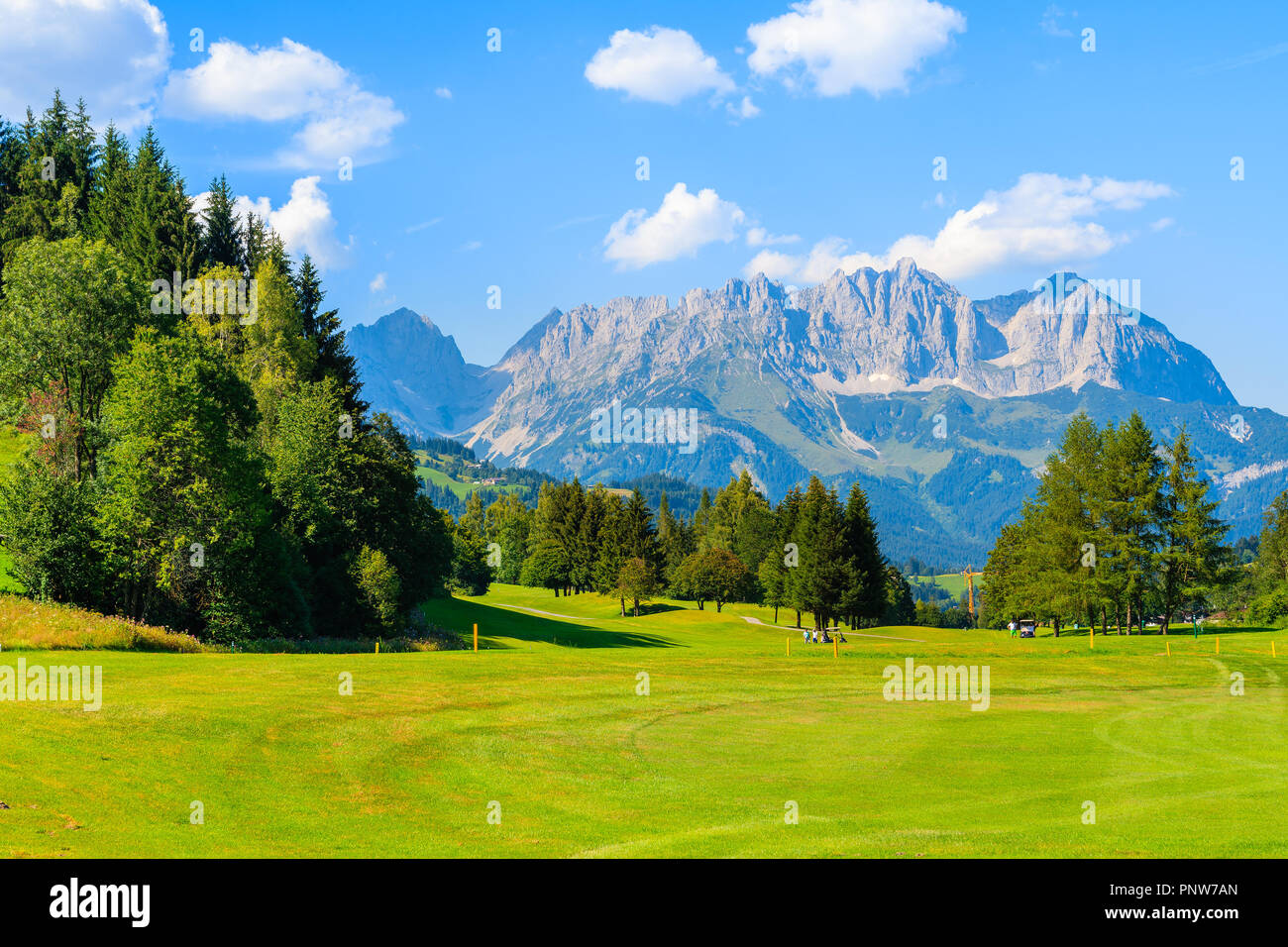 Verdi campi da golf zona contro lo sfondo delle montagne su soleggiate giornate estive, Kitzbuhel, Tirolo, Austria Foto Stock