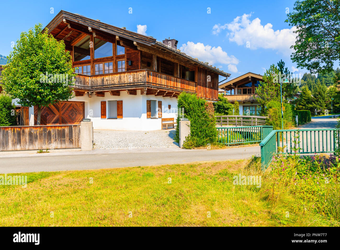 Case tradizionali sul prato verde in Reith villaggio di montagna, a Kitzbuhel Alpi, Austria Foto Stock