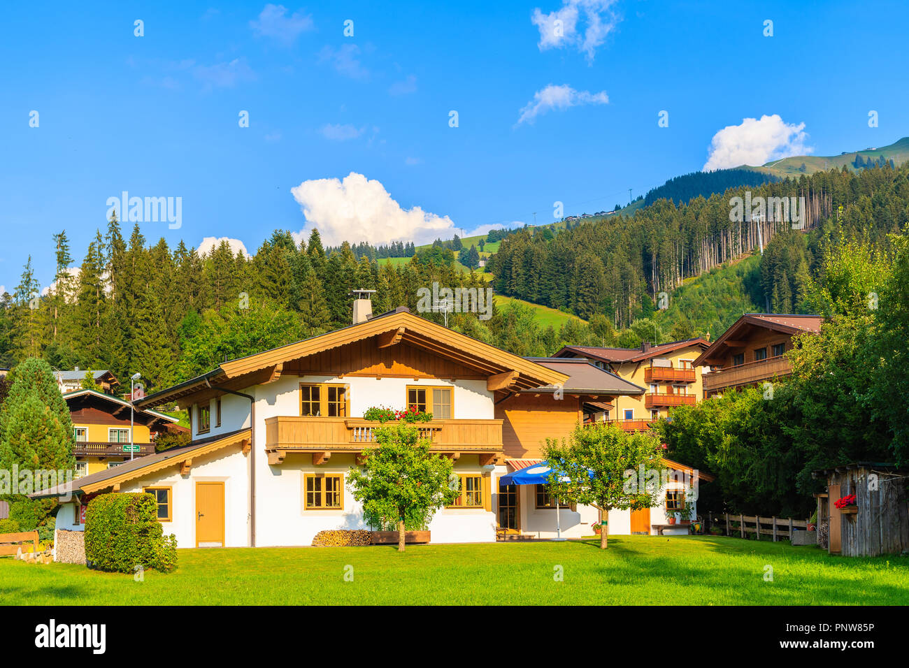 Casa Tradizionale su prato verde a Kirchberg mountain village,sulla bella soleggiata giornata estiva, Alpi Kitzbühel, Austria Foto Stock
