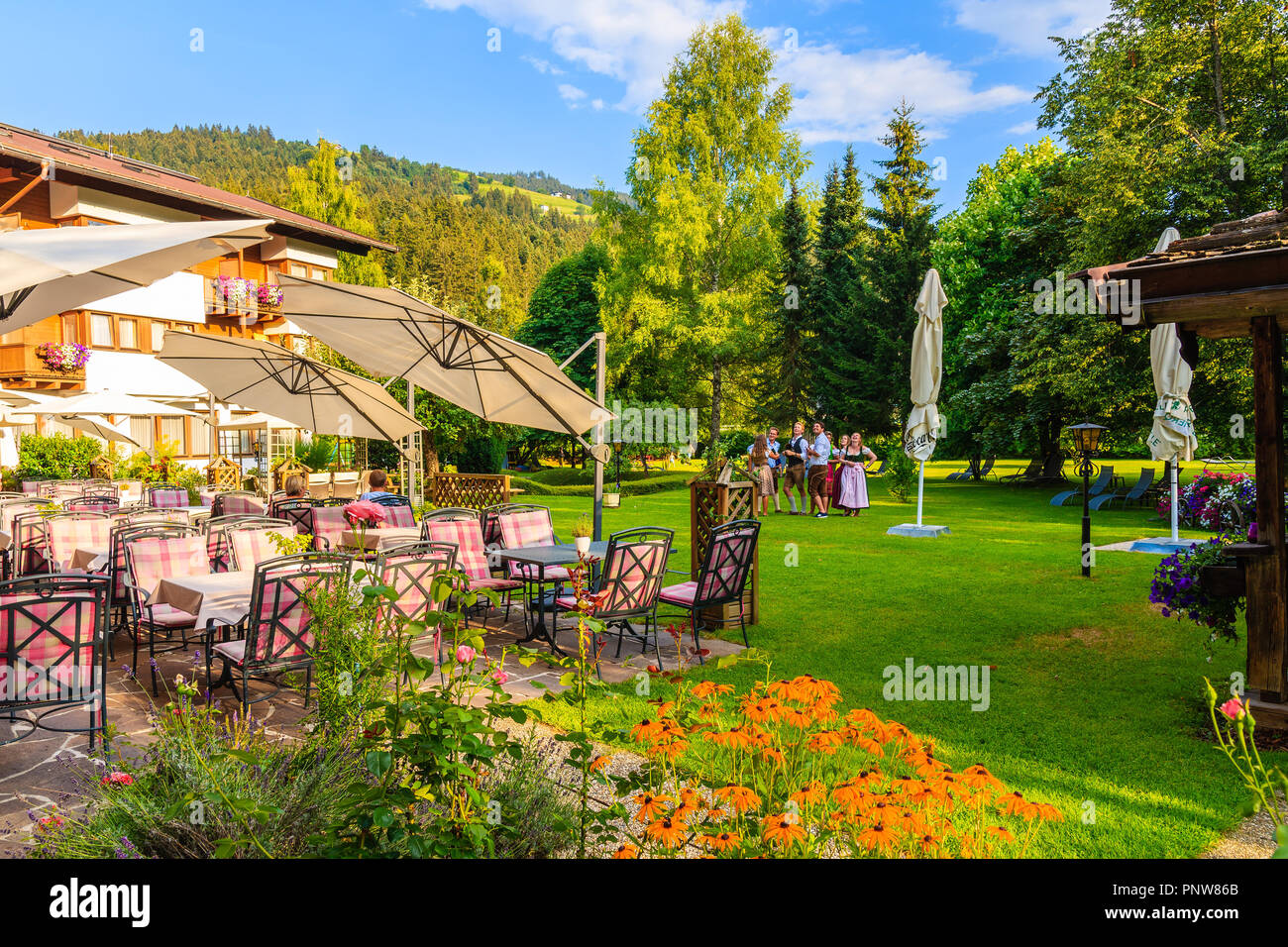 KIRCHBERG IN TIROL, Austria - Agosto 4, 2018: Ristorante in giardino verde in un lussuoso hotel alpino sul giorno di estate. Kirchberg è un villaggio di montagna situato in Foto Stock