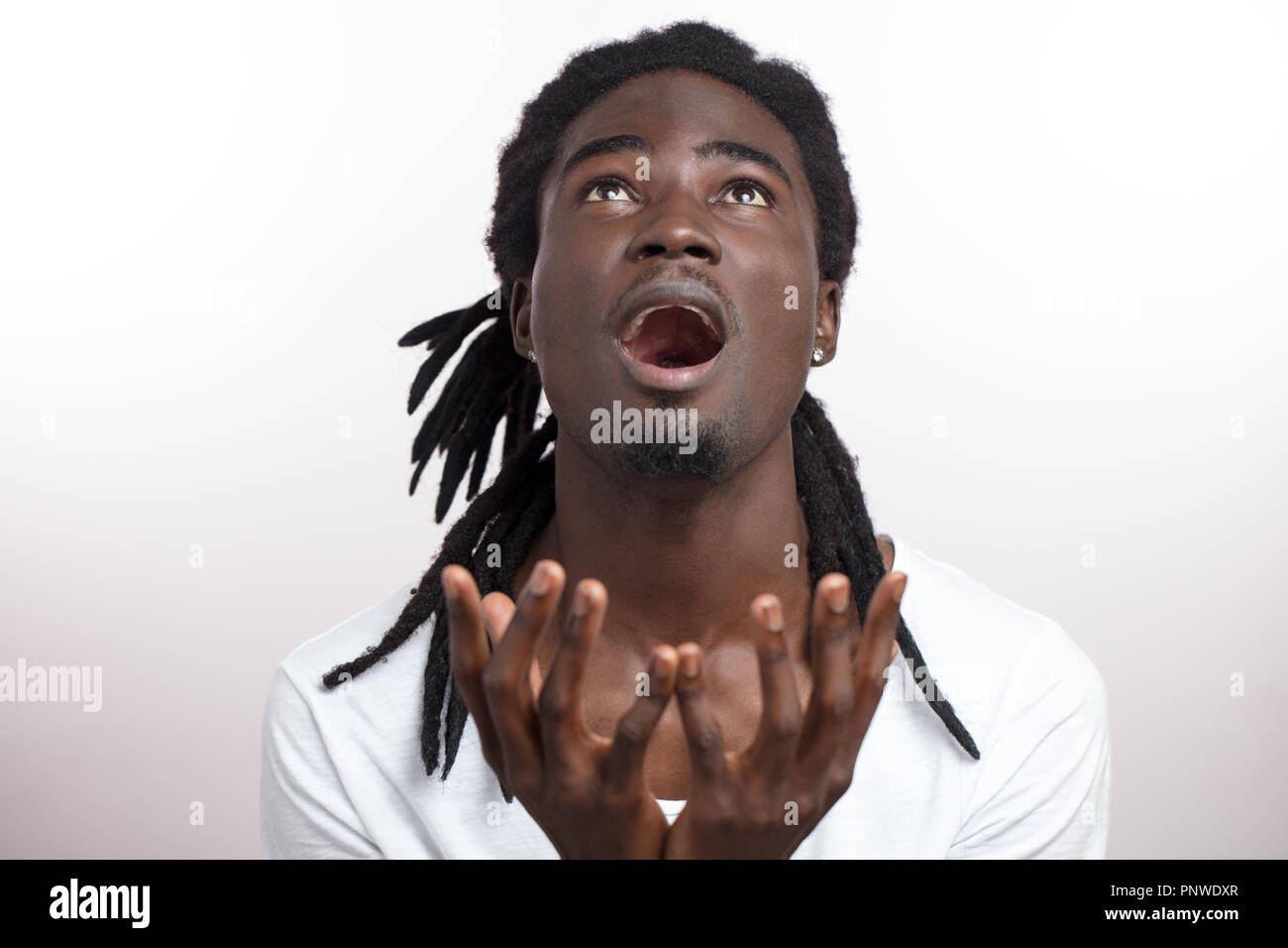 Uomo che guarda verso l'alto e dire di no a Dio o perché con le mani alzate Foto Stock