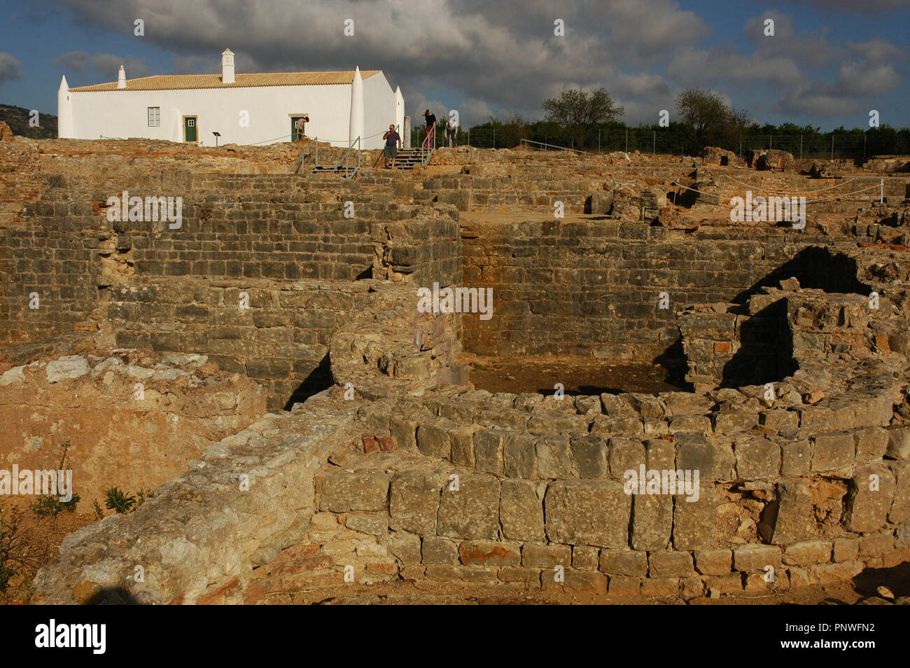 Rovine di Milreu. Villa Romana (1° - 4° secolo D.C.). In primo piano, i bagni. Dietro, una cinquecentesca casa. Estoi, vicino a Faro. Algarve. Il Portogallo. Foto Stock