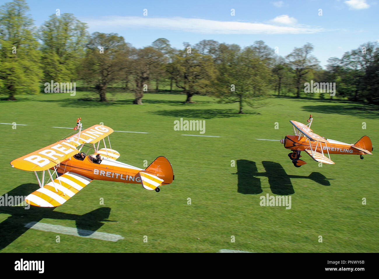 Aerosuperbatics Breitling Wingwalkers Boeing Stearman gli aerei che decollano da Henham Park erba pista di atterraggio per aerei nella campagna di Suffolk. Giornata di sole Foto Stock