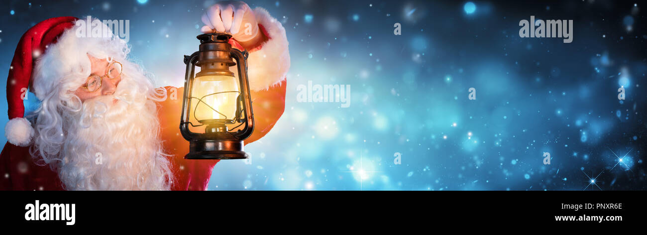 Babbo Natale con la lanterna nella notte nevosa Foto Stock