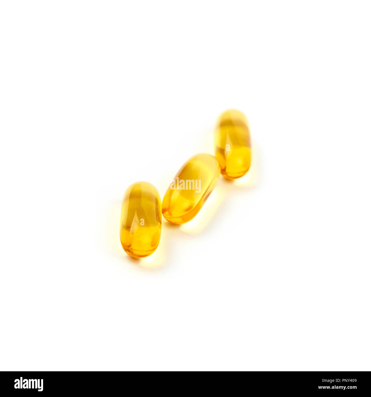 Chiudere fino tre gialli di Omega 3 vitamine essenziali e oli di pesce tappo di gel pillole isolati su sfondo bianco, ad alto angolo di visione Foto Stock